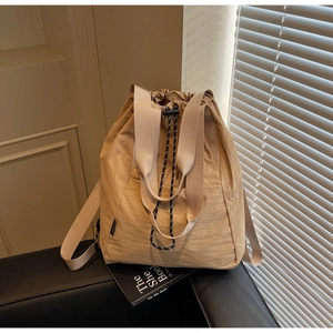 Close-up of khaki plaid bucket bag with drawstring closure and durable nylon texture