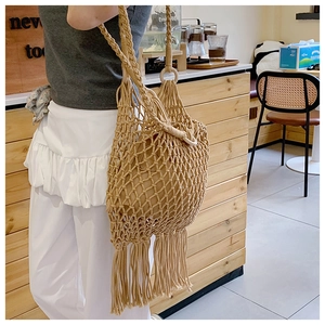 Détail du sac à bandoulière en maille tissée avec de longues franges au café