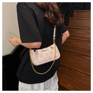 Pink chain crossbody bag with cartoon print shown on person for size and style reference