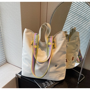 Detail of canvas tote with colorful floral SJCHAO shoulder strap in a mirror reflection