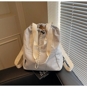 Detailed shot of the blue checkered pattern fabric and drawstring closure on the tote bag