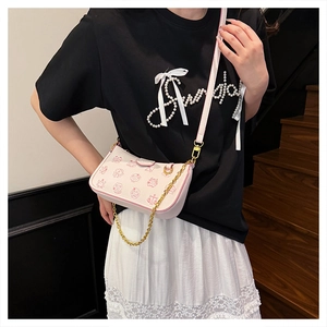 Détail du sac bandoulière rose avec imprimés cartoon et chaîne dorée pour femme