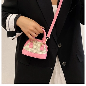 Detail von rosa Lederbesatz und beigem Webmuster auf einer Mini-Muschel-Umhängetasche