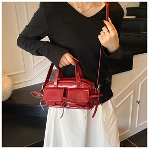 Détail du sac à main rouge brillant avec poches à rabat et bandoulière réglable