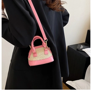 Mini-Muschel-Tasche aus rosa Leder und Stroh, getragen zu einem schwarzen Blazer