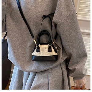 Detailansicht einer Mini-Tasche in Muschelform mit Webstruktur und goldenen Metallhaken