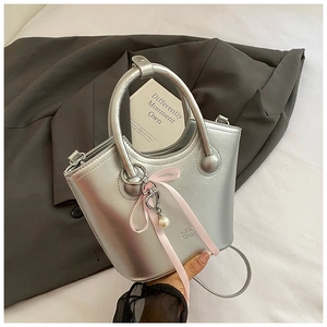 Sac seau métallisé argenté avec nœud rose, breloque perle et porte-clé cœur de détail
