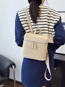 Chic cream-colored PU leather backpack for women shown from a side back view on a model