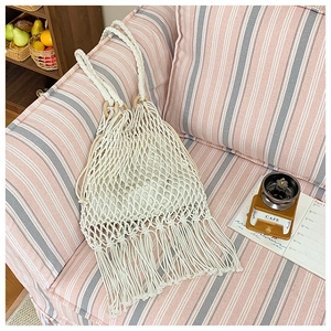 Détail du sac bandoulière en maille avec poignée ronde en bois et longues franges