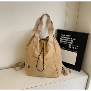 Detail view of khaki waterproof drawstring tote bag with black and white patterned cord