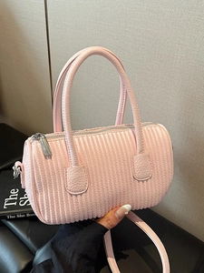 Pink pleated cylinder crossbody bag with top handles and adjustable strap in soft light