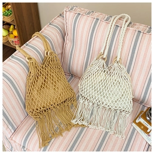 Détail du sac de plage tissé avec anneaux en bois, longues franges et doublure en tissu