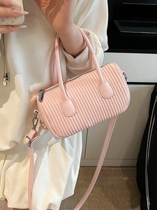 Pink pleated cylindrical crossbody bag with top handle and adjustable shoulder strap