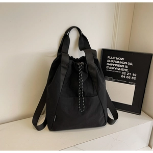 Detail of black drawstring backpack showing woven label and durable fabric texture