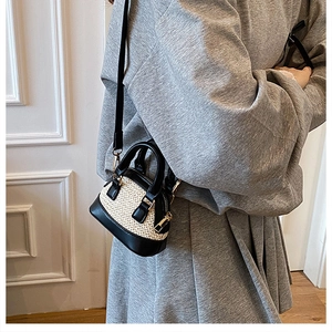 Mini-Muscheltasche aus Stroh und schwarzem Leder im Kontrast-Look am Modell