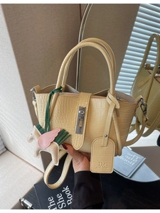 Yellow crocodile pattern handbag with metal lock, leather horse charm and a book