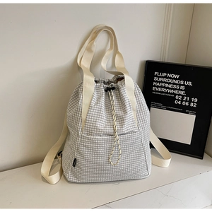 Detail view of the drawstring closure and checkered fabric on the stylish bucket bag