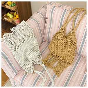 Détail du sac à bandoulière tressé avec franges et anneaux de connexion en bois