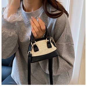 Nahaufnahme der Mini-Stroh-Muscheltasche mit schwarzem Lederbesatz und Gold-Hardware