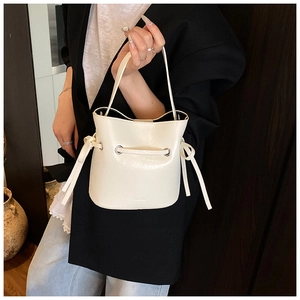 Close-up of ivory bucket bag showing PU leather texture and NIUOLO logo engraving