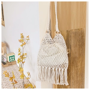 Détail du sac à bandoulière en macramé blanc avec franges et anneau en bois
