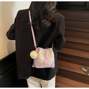 Detailed view of light purple bucket bag with vintage jacquard pattern and plush charm