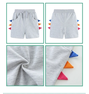 Detailed views of grey knitted boys shorts featuring colorful dinosaur scale decorations