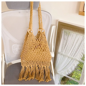 Vue détaillée du sac tissé kaki avec un design ajouré et de longues franges bohèmes