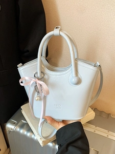 Sac fourre-tout en cuir brillant bleu clair avec un nœud en soie rose et perle