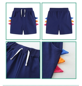 Detail of dark blue knit boys' shorts featuring colorful 3D dinosaur fin side decorations