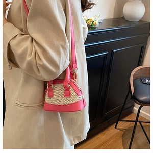 Detail der Mini-Muschel-Umhängetasche mit rosa Lederbesatz und gewebter Strohstruktur