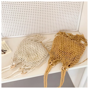 Détail du sac tissé à franges avec poignée en bois en couleurs beige et kaki