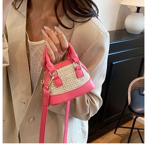 Mini-Muscheltasche aus rosa Leder und Strohgewebe an einem weiblichen Modell