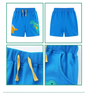 Detail shots of blue dinosaur print shorts with elastic waist and yellow drawstring