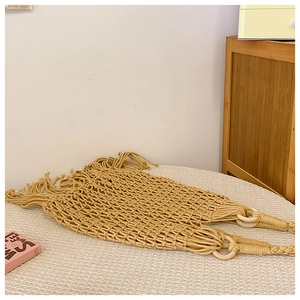 Détail du sac à bandoulière tissé jaune avec poignées en bois et longues franges
