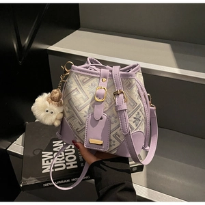 Detail showing lavender leather trim and geometric jacquard fabric of the bucket bag