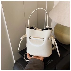 Detail of cream bucket bag with vintage wrinkled texture and bow drawstring decoration