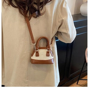 Mini-Muschel-Tasche aus Stroh und braunem Leder, getragen zu einem beigen Trenchcoat
