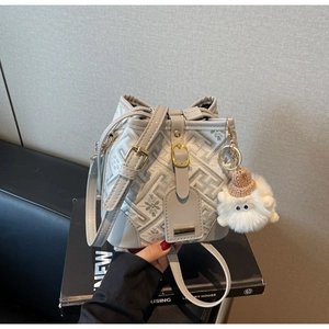 Detail of grey bucket bag with geometric patterns, drawstring closure and monster charm