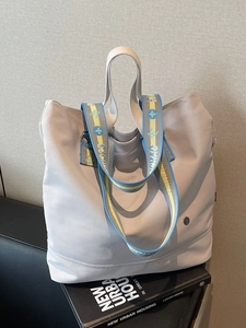 Minimalist light grey canvas tote bag with decorative embroidered wide shoulder strap