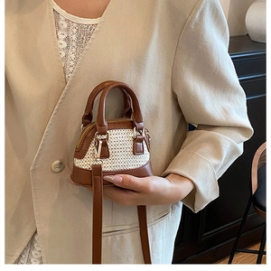 Detail der Mini-Muschel-Tasche mit braunem Webmuster und Lederakzenten