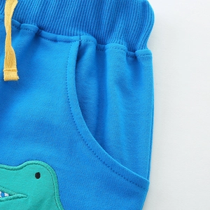 Boys blue cotton shorts with elastic waist, yellow drawstring, and green crocodile embroidery