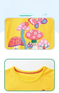 Detail of yellow cotton kids t-shirt with mushroom cartoon print and reinforced neckline