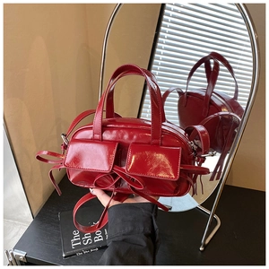 Détails du sac à main en cuir verni rouge foncé avec fini brillant et nœuds décoratifs