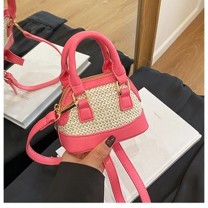 Detail der rosa Leder- und Strohtextur an einer Mini-Muschel-Umhängetasche für Damen
