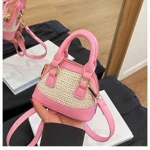 Detail einer Mini-Muscheltasche aus rosa Leder und beigem geflochtenem Stroh