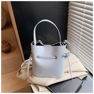 Detailed view of light blue bucket bag with cracked leather texture and drawstring
