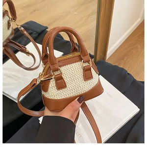 Detailansicht der Mini-Muscheltasche aus Strohgeflecht und braunem Kunstlederbesatz