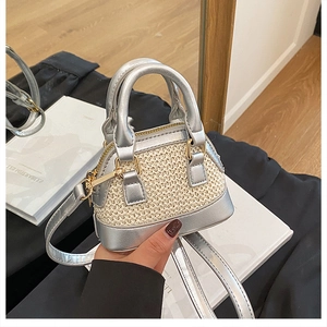 Nahaufnahme der silbernen PU-Leder-Nähte an einer beige gewebten Stroh-Mini-Muscheltasche