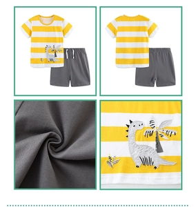 Détail de broderie dinosaure sur t-shirt rayé en coton et short gris pour petit garçon